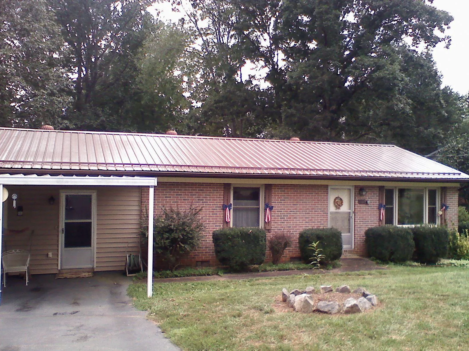 Bronze metal roof and carport on a brick ranch home — Roof Repair work by our crew in Trion
